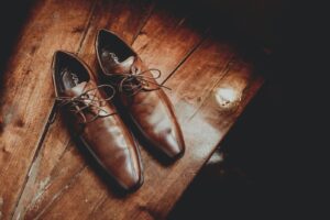 Elegant brown leather shoes on wooden surface